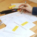 Julien designing website wireframes and user profiles with pen and paper